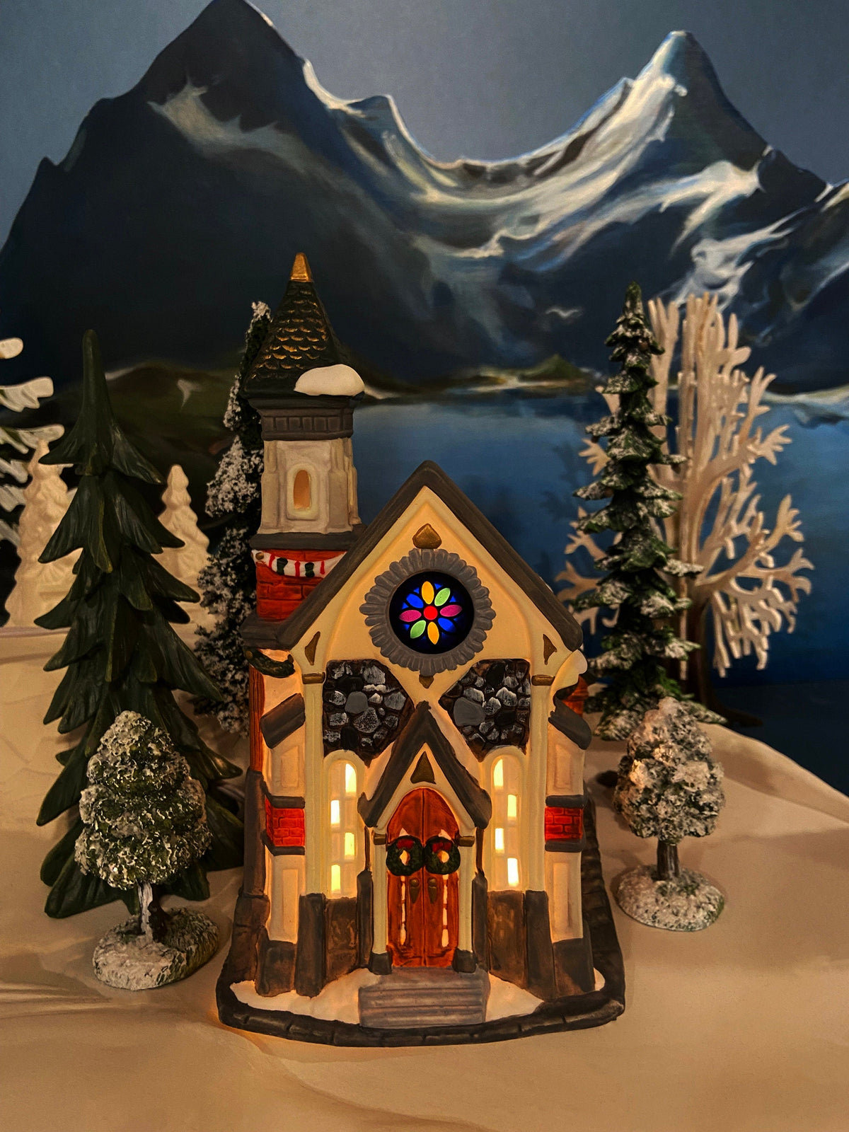 Christmas Village Church with Stained Glass Window. Illuminated House of Worship. Holiday Decor. Christmas Celebration.