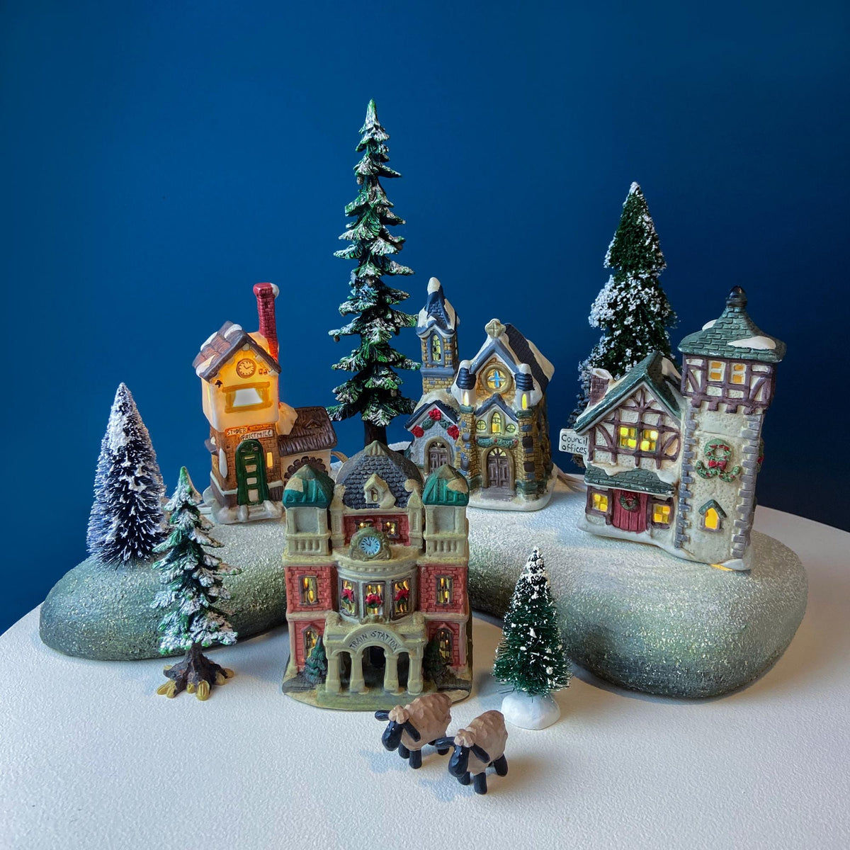 Christmas Village Collection of Small Illuminated Houses. Set of 4 Bldgs: Mill, 2 Churches, Train St., Council Offices, 2 Sheep and 3 Pines.